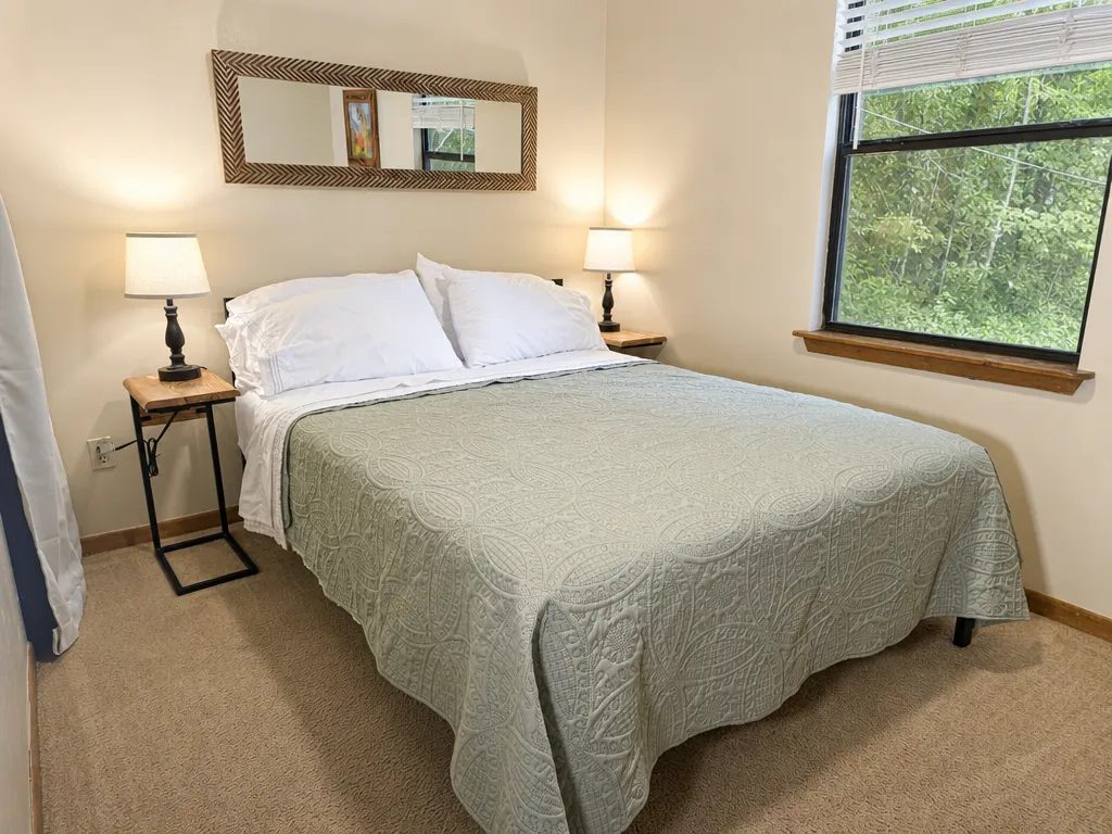 Queen bedroom with wood wainscoting and a blue quilt